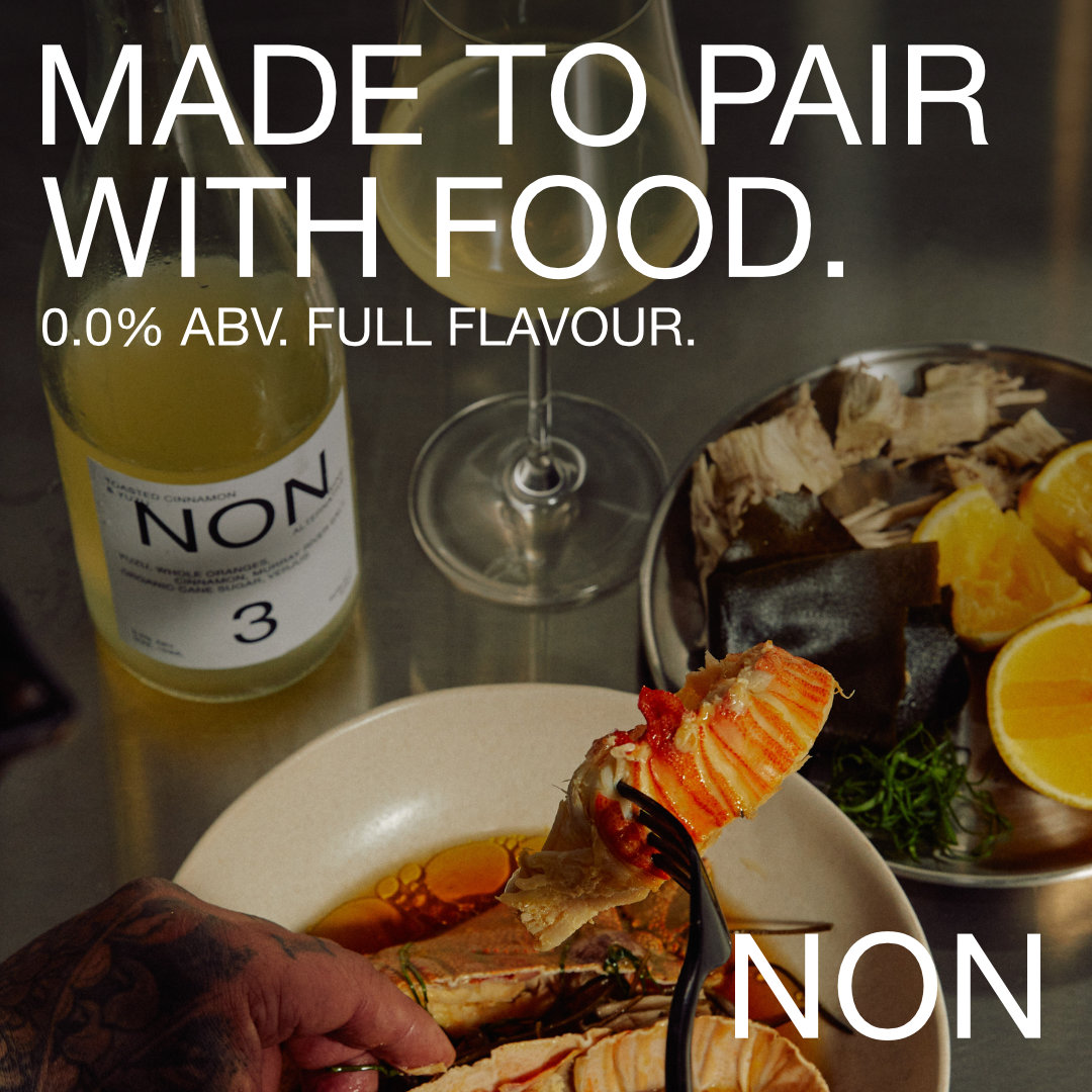 A bottle of NON 3 and a glass of it beside a bowl of seafood being eaten, under the headline “Made to pair with food. Full flavour.”